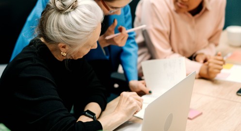 People reviewing reports on paper and laptop